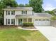 Charming two-story home features a manicured lawn, inviting entrance, and attached two-car garage at 6006 Lanier Heights Cir, Buford, GA 30518