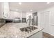 Modern kitchen features granite counters, white cabinets, and stainless steel appliances at 6006 Lanier Heights Cir, Buford, GA 30518