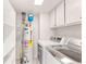 Well-equipped laundry room with modern washer and dryer, shelving, and water heater for convenience at 6006 Lanier Heights Cir, Buford, GA 30518