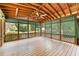 Large screened in back porch with wooden ceiling, wooden floor and ceiling fan at 6006 Lanier Heights Cir, Buford, GA 30518