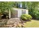 Exterior view of the home's shed with double doors and one window, nestled among mature trees in the back yard at 6006 Lanier Heights Cir, Buford, GA 30518