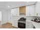 Modern kitchen with white cabinets, stainless steel appliances and a wood accent range hood at 3939 Hamilton Mill Rd, Buford, GA 30519