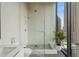 Contemporary bathroom with a glass shower, tiled floor, and a sink with a city view at 40 12Th Ne St # 1903, Atlanta, GA 30309