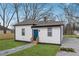 White house with a blue door, surrounded by trees and a grassy yard at 1617 Church Ne St, Conyers, GA 30012