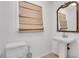 Compact half bathroom with pedestal sink, toilet, and neutral decor, ideal for guests at 2225 Mountain Creek Dr, Tucker, GA 30087