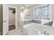 Relaxing bathroom with soaking tub, walk-in shower, and stained glass window at 4684 Pine Dr, Loganville, GA 30052
