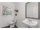 Small powder room with pedestal sink, toilet and decorative mirror at 652 Kimberwick Dr, Locust Grove, GA 30248