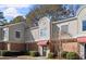 Brick townhouse with gray siding, red awning, and landscaping at 3301 Henderson Mill Rd # A2, Atlanta, GA 30341