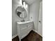 Modern bathroom with white vanity, marble countertop, and circular mirror at 7035 Stone Wood Nw Dr, Kennesaw, GA 30152
