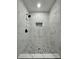 Walk-in shower with marble tile, pebble floor, and built-in niche at 7035 Stone Wood Nw Dr, Kennesaw, GA 30152