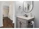 Small bathroom with gray vanity, black fixtures and a modern circular mirror at 1170 Rose Terrace Cir, Loganville, GA 30052