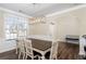 Bright dining room features a spacious table, hardwood floors, and elegant light fixture at 1170 Rose Terrace Cir, Loganville, GA 30052