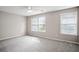 Spacious bedroom with neutral walls, plush carpet, and two windows at 3742 Berkeley Xing, Duluth, GA 30096