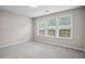 Bright bedroom with three windows, neutral paint, and plush gray carpeting at 3742 Berkeley Xing, Duluth, GA 30096