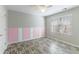 Bright bedroom with wood-look flooring and pink and white accent wall at 3886 Cedar Trace Ln, Ellenwood, GA 30294