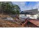 Exterior view of house, showcasing a deck, patio, and surrounding woods at 3886 Cedar Trace Ln, Ellenwood, GA 30294
