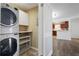 Stackable washer and dryer in a well-lit laundry room with extra shelving at 1647 Raleigh Se Cir, Marietta, GA 30067