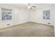 Bright bedroom with carpet flooring, ceiling fan, and two windows at 19 Roving Hills Cir, Cartersville, GA 30121