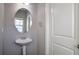 Small bathroom with pedestal sink and oval mirror at 157 Parkview Place Dr, Mcdonough, GA 30253