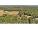 Aerial view of a house with a large field adjacent to a wooded area at 248 Billy Bullock Rd, Dallas, GA 30157