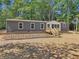 Single-wide manufactured home with gray siding, wood deck, and landscaping at 248 Billy Bullock Rd, Dallas, GA 30157