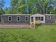 Gray and white single-wide manufactured home with wooden deck and steps at 248 Billy Bullock Rd, Dallas, GA 30157