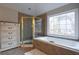 Bathroom features a shower, soaking tub, and elegant window at 1429 Wood Iris Ln, Lawrenceville, GA 30045