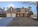 Brick two-story house with a three-car garage and landscaped yard at 1429 Wood Iris Ln, Lawrenceville, GA 30045