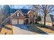 Two-story brick home with attached garage and landscaping at 1429 Wood Iris Ln, Lawrenceville, GA 30045