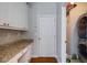 Laundry room with white cabinets, granite countertop, and access to utility closet at 1429 Wood Iris Ln, Lawrenceville, GA 30045