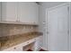 White cabinets and granite countertop in a functional laundry room at 1429 Wood Iris Ln, Lawrenceville, GA 30045