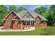 Beautiful brick home featuring a well-manicured lawn and a charming covered front porch entrance at 6020 Cochran Mill Rd, Chattahoochee Hills, GA 30268