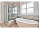 Bright bathroom featuring a glass-enclosed shower and freestanding soaking tub by a window with shutters at 1250 Atherton Park, Roswell, GA 30076