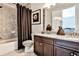 Bathroom with granite-topped dark wood vanity and shower-tub combo with shower curtain at 1250 Atherton Park, Roswell, GA 30076