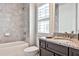 Bathroom featuring vanity with granite countertop, sink, and bathtub with gray tile surround at 1250 Atherton Park, Roswell, GA 30076