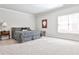 Spacious bedroom features neutral walls and carpet, a queen bed with patterned linens, and a small side table at 1250 Atherton Park, Roswell, GA 30076