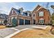 Elegant brick home featuring a three-car garage, manicured landscaping, and a welcoming entrance at 1250 Atherton Park, Roswell, GA 30076