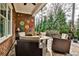 Relaxing covered patio with outdoor seating, brick wall with flower decor, and view of landscaped yard at 1250 Atherton Park, Roswell, GA 30076