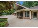 Brick home exterior featuring a large patio with an umbrella, white chairs and outdoor dining at 3781 Anneewakee Rd, Douglasville, GA 30135