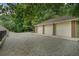Spacious three-car garage with brick exterior and gravel driveway at 3781 Anneewakee Rd, Douglasville, GA 30135