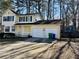 Two-story yellow house with a white garage and mature trees at 5615 Pennybrook Ct, Stone Mountain, GA 30087