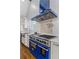 Gourmet kitchen features a blue range hood, stainless steel appliances, and subway tile backsplash at 1290 Pasadena Ne Ave, Atlanta, GA 30306