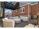 Backyard brick patio with a dark pergola and curved wicker outdoor seating at 1290 Pasadena Ne Ave, Atlanta, GA 30306