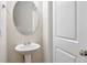 Small bathroom with pedestal sink and oval mirror at 161 Parkview Place Dr, Mcdonough, GA 30253