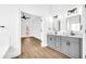 Main bathroom with double vanity, gray cabinets and access to bedroom at 3110 Haverhill Ne Cv, Conyers, GA 30012