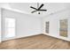 Bright bedroom featuring hardwood floors, ceiling fan, and multiple windows at 3110 Haverhill Ne Cv, Conyers, GA 30012
