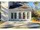 White house exterior with sunlit patio and french doors at 3110 Haverhill Ne Cv, Conyers, GA 30012