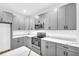 Modern kitchen with gray cabinets, white countertops, and stainless steel appliances at 3110 Haverhill Ne Cv, Conyers, GA 30012