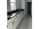 Bathroom with double vanity, black countertops, and marble floors at 5043 Baywood Ln, Woodstock, GA 30188