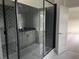 Modern bathroom features a glass shower with grey herringbone tiling and a black frame at 5043 Baywood Ln, Woodstock, GA 30188